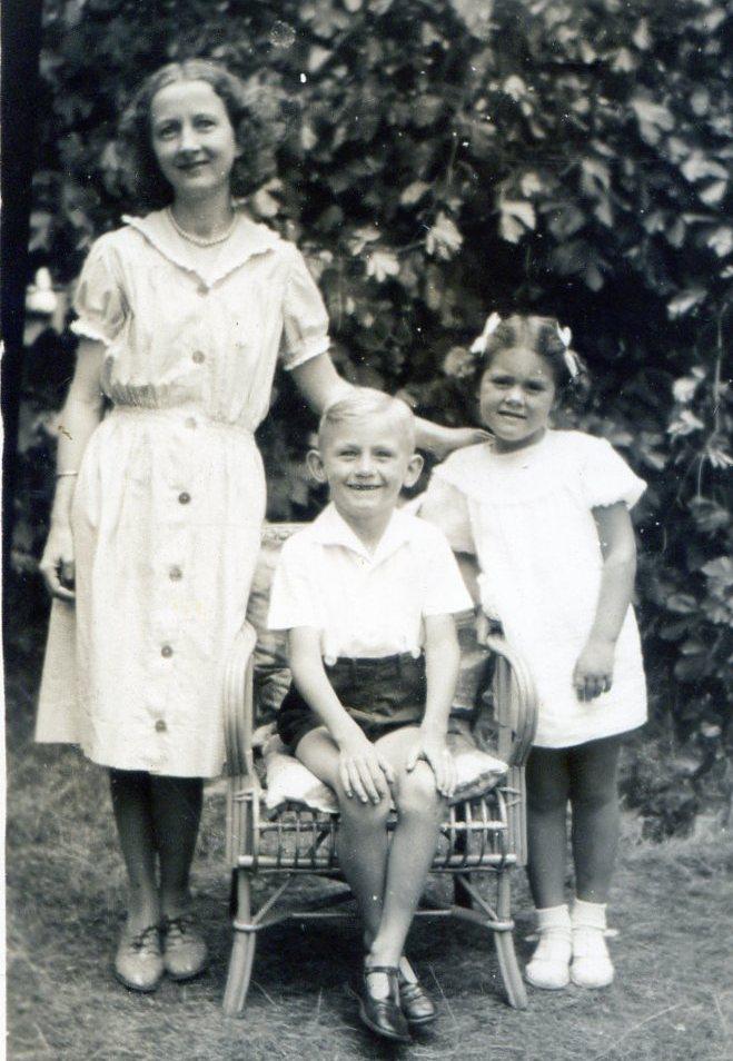 Junior seated in ‘The Cane Chair’, Mum on the left and Elizabeth Withell on the right. Grape vines behind.