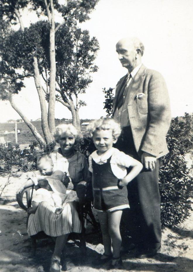 At grand parents home in Swansea Street, Victoria Park. Grandma seated holding baby Robin Coverley, Junior and Grandad.